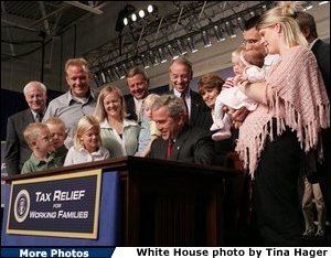 President George W. Bush signs H.R. 1308, the Working Families Tax Relief Act of 2004 at the South Suburban YMCA in Des Moines Iowa, Monday, Oct. 4, 2004. White House photo by Tina Hager.