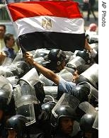 A demonstrator flies an Egyptian flag over riot police in support of pro-reform judges