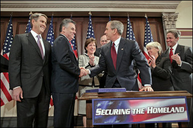 President George W. Bush shakes hands with Congressman Peter King, R-N.Y., chairman of the Homeland Security Committee, after signing H.R. 4954, the SAFE Port Act, in the Dwight D. Eisenhower Executive Office Building Friday, Oct. 13, 2006. Also pictured from left are Sen. Bill First, R-Tenn.; Sen. Susan Collins, R-Maine; Sen. Robert Bennett, R-Utah; Sen. Patty Murray, D-Wash.; and Sen. Norm Coleman, R-Minn. White House photo by Paul Morse