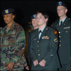 Pvt. Lynndie England, 372nd Military Police Company, is escorted by guards and her defense counsels, Capt. Jonathan Crisp and Capt. Katherine Krul, from Fort Hoods Williams Judicial Center Tuesday night after she was sentenced to three years for prisoner abuse at Abu Ghraib. 