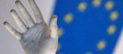 The hand of a status seen against the EU logo at the EU Council HQ in Brussels