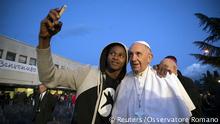 Pope Francis in a selfie with a refugee in a migrant center near Rome. The pontiff may travel to Lesbos